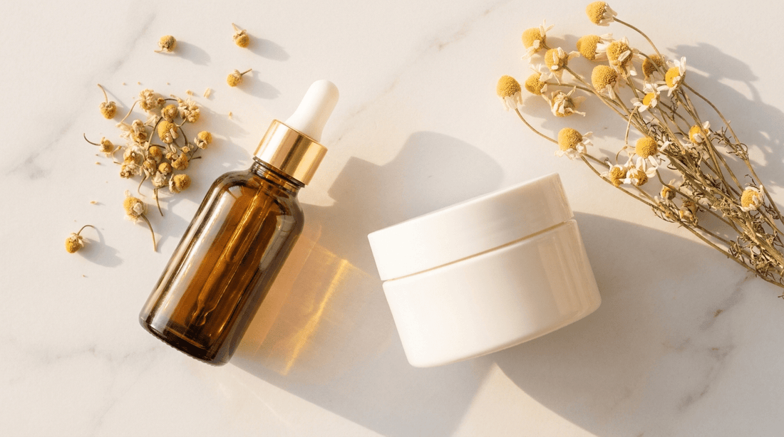 Amber glass dropper bottle and cream jar on marble surface with chamomile flowers — K-beauty retinal skincare editorial