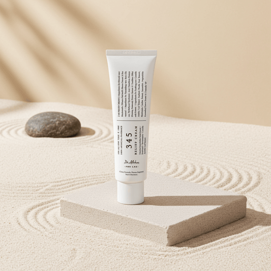 Tube of cream on a sand-like surface with a stone and wooden block